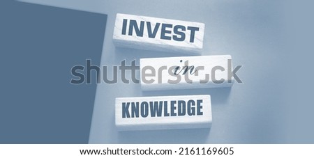 Invest in knowledge words onwooden blocks. Inspirational motivational quote. Investment in knowledge pays the best dividends, education or business training concept.