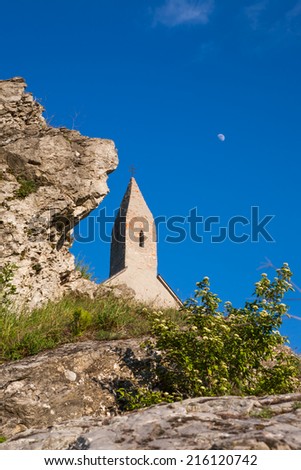 Old church of St. Michael against the blue sky with moon