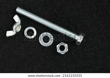 M8 bolt on a black background with two nuts and washers