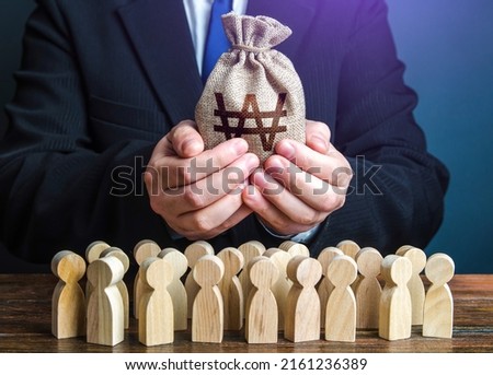 Businessman holds out a south korean won money bag to the crowd. Official. Staff maintenance. Tax collection. Compensation payments. Providing money, paying salaries and grants. Financial support. Royalty-Free Stock Photo #2161236389