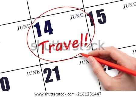 14th day of June. Hand drawing a red circle and writing the text TRAVEL on the calendar date 14 June. Travel planning. Summer month. Day of the year concept.