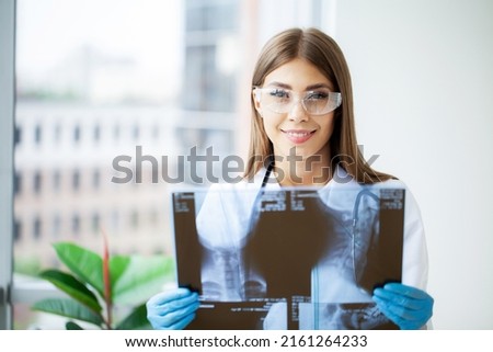 Young female doctor looking at the x-ray picture of in hospital
