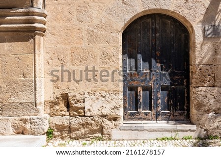 Antique  door and stone wall in day light.