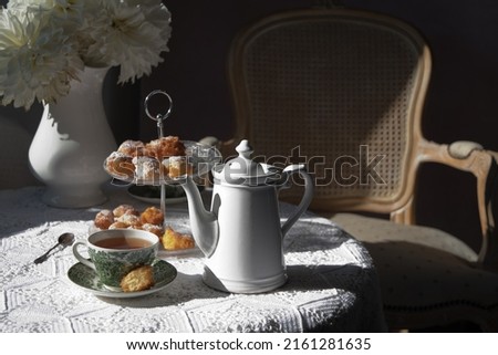 tea break in the English style, still life with flowers and donuts in the sun Royalty-Free Stock Photo #2161281635