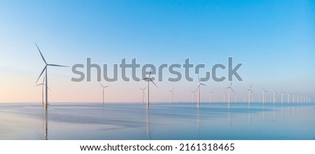 Windmill park in the ocean, drone aerial view of windmill turbines generating green energy electric, windmills isolated at sea in the Netherlands. High quality 4k footage Royalty-Free Stock Photo #2161318465