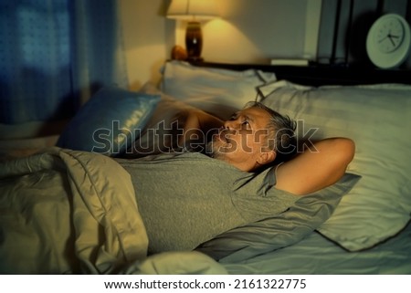depressed old man and stressed lying in bed from insomnia Royalty-Free Stock Photo #2161322775