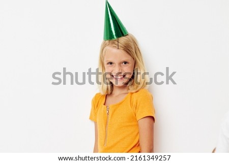 a girl with a green cap on her head gestures with her hands