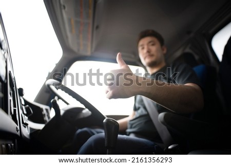 Male truck driver thumbs up