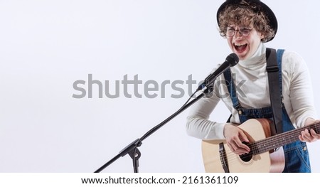 Happy mood. Portrait of young emotiona man, musician playing acoustic guitar and singing isolated on white background. Concept of art, music, style and creation. Copy space for ad