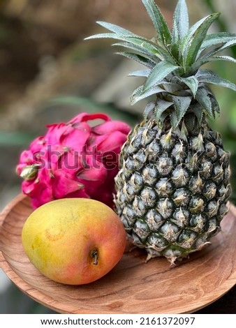 dragon fruit ,pineapple and mango on the wood plate in tropical
