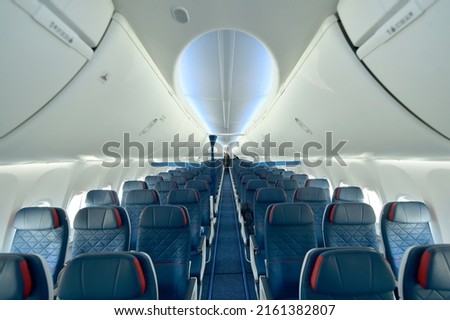 Empty interior of modern airplane Boeing 737-8 Max with blue seats and no passangers. Royalty-Free Stock Photo #2161382807