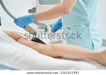 Beautician processing hip with vela shape apparatus Royalty-Free Stock Photo #2161411941