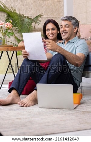 Beautiful couple using laptop while working on home budget