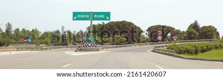 motorway junction with the Italian indications for the city of VENICE on the LEFT or MILAN if you turn RIGHT without cars