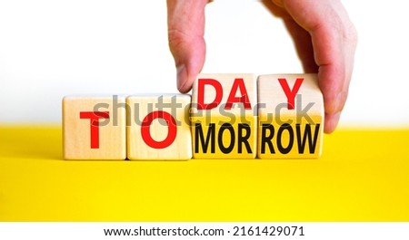 Do it today not tomorrow. Businessman turns wooden cubes and changes the word 'tomorrow' to 'today'. Beautiful yellow table, white background, copy space. Business and tomorrow or today concept.