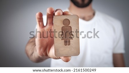 Caucasian man showing wooden female symbol.