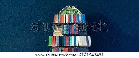 Aerial drone top down ultra wide photo of colourful truck size container tanker ship cruising deep blue sea near commercial port of Piraeus, Attica, Greece
