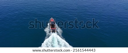 Aerial drone ultra wide photo of luxury rigid inflatable speed boat cruising in high speed in Aegean deep blue sea, Greece