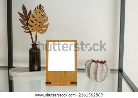 Layout of photo frame on glass shelf. Lifestyle hipster home decoration and travel concept