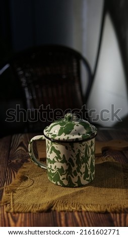 Teapot for making tea. In Indonesia, this teapot is called Teko Blirik. Made of zinc and enamel coating for heat resistance. Patterned like an army uniform. Indonesia.