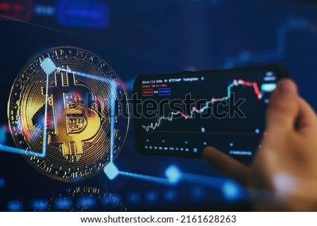 Bitcoin cryptocurrency gold coin on smartfone. Trading on the cryptocurrency exchange. Gold Bitcoin crypto currency on background