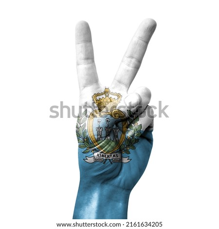 Hand making the V victory sign with flag of san marino