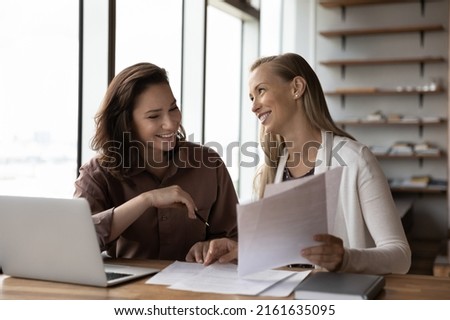 Happy business colleagues analyzing, reviewing project papers, legal documents together. Customer and legal expert meeting at workplace for paperwork. Mentor explaining contract to interns Royalty-Free Stock Photo #2161635095