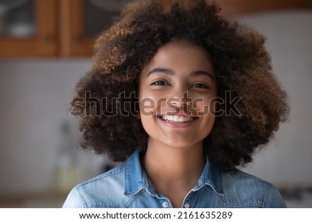 Headshot portrait happy cheering beautiful African American teen female look at camera with toothy hollywood smile make video call. Gen z lady satisfied client shoot video feedback on goods service Royalty-Free Stock Photo #2161635289