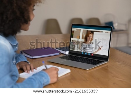 Happy positive African student girl studying English foreign language, talking to teacher in video call, watching online lesson, virtual class, workshop, taking training course. Screen view Royalty-Free Stock Photo #2161635339