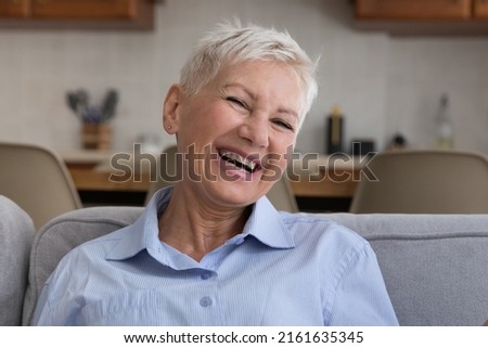 Happy and healthy. Headshot portrait emotional positive old lady with stylish short hairdo laugh on joke demonstrate toothy smile. Attractive elderly female pensioner look at camera feel joy good mood