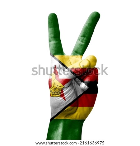Hand making the V victory sign with flag of zimbabwe