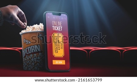 Movie tickets online booking app on smartphone, popcorn and movie seats in the background Royalty-Free Stock Photo #2161653799