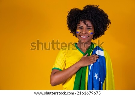 Brazilian fan. wearing Brazilian flag in a portrait, Brazilian fan celebrating football or soccer game on yellow background. Colors of Brazil.World Cup Royalty-Free Stock Photo #2161679675