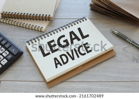 Legal Advice . text on an open notepad. on a wooden table near a craft notepad