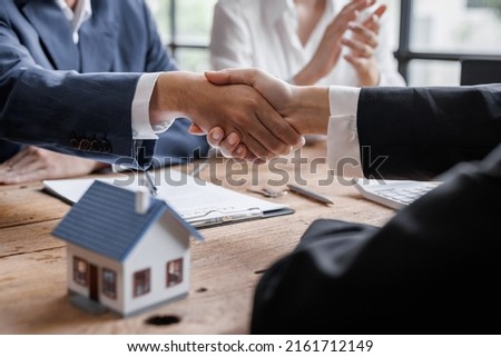 Real estate brokerage agent Deliver a sample of a model house to the customer, mortgage loan agreement Making lease and buy and sell house And contract home insurance mortgage loan concept Royalty-Free Stock Photo #2161712149