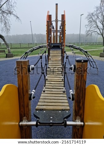 Kinder playground with modern infrastructure. Public playground with soft rubber coating.  Park with activities for preschool kids. Royalty-Free Stock Photo #2161714119