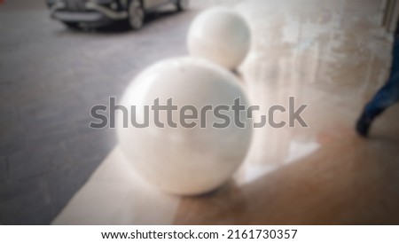 Defocused abstract background of 
White marble, shaped like a ball. As a decoration on the terrace of an office building. Very beautiful.