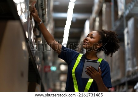 African American worker checking the stock on shelf in warehouse comparing the balancing number in system after delivery shipment. Using tablet to update online stock available for selling on website Royalty-Free Stock Photo #2161731485