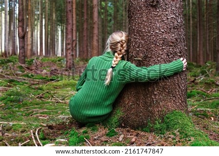 Woman sitting in forest and enjoys beauty of nature. Royalty-Free Stock Photo #2161747847