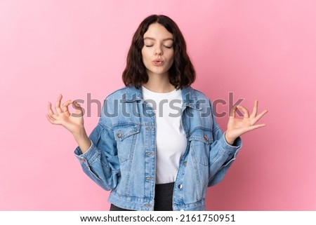Teenager Ukrainian girl isolated on pink background in zen pose