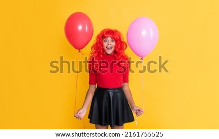 amazed teen child with party balloon on yellow background