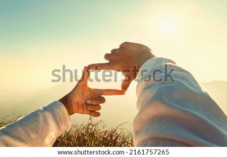 woman hand framing looking view sunrise