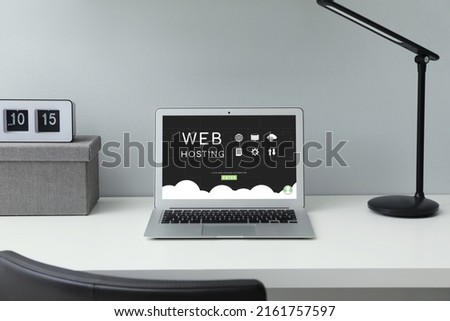 Web hosting service. Comfortable workplace with modern laptop on white table
