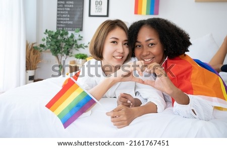 Diversity African American  Asian Married couples Lesbian LGBTQ.Engaged homosexual Hug together Rainbow flag.Sexual equality,LGBT Pride month,Parade celebrations concept.Family of happiness smiling. Royalty-Free Stock Photo #2161767451