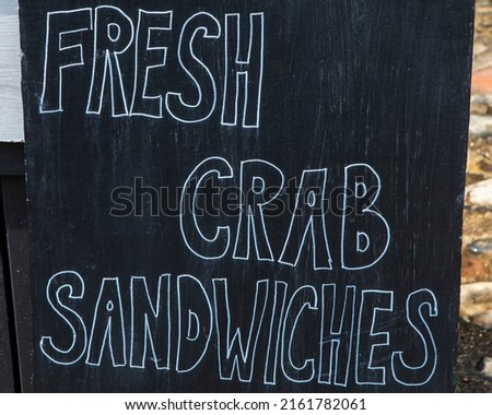 A sign advertising Fresh Crab Sandwiches on sale in the seaside town of Sheringham in Norfolk, UK.