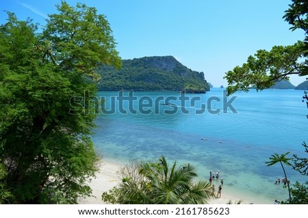 blue water lagoon, boat in the distance, green hill near sea, tropical beach, travel destination 