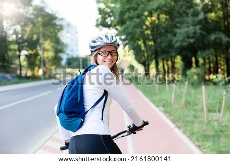 Happy woman riding bike on city street. Road with bicycle path. Cyclists Royalty-Free Stock Photo #2161800141