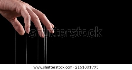 Banner with man hand with strings on fingers. Manipulation or addiction concept. Master, abuser using influence to control person behavior. Copy space. High quality photo