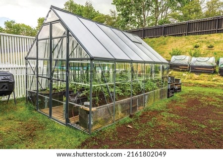 Gorgeous view of exterior of a private small garden with greenhouse.  Sweden.  Royalty-Free Stock Photo #2161802049