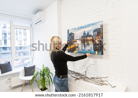 Photo canvas print. A woman holding a photography with gallery wrap. Photo printed on glossy synthetic canvas and stretched on stretcher bar Royalty-Free Stock Photo #2161817917